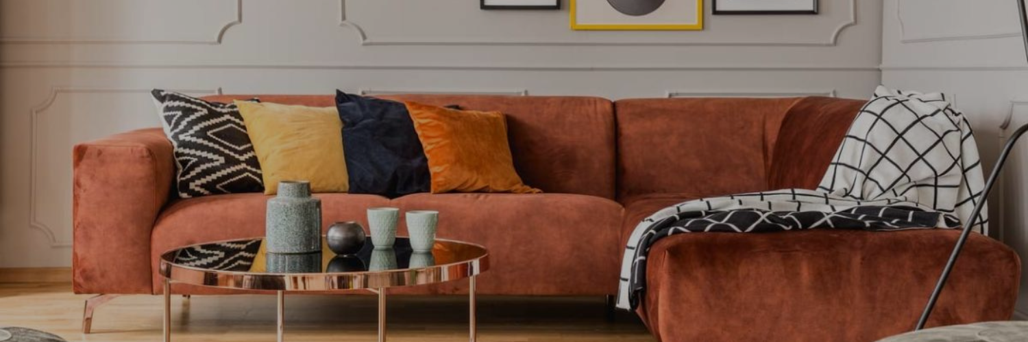 orange colour sofa with multiple cushions in a living room