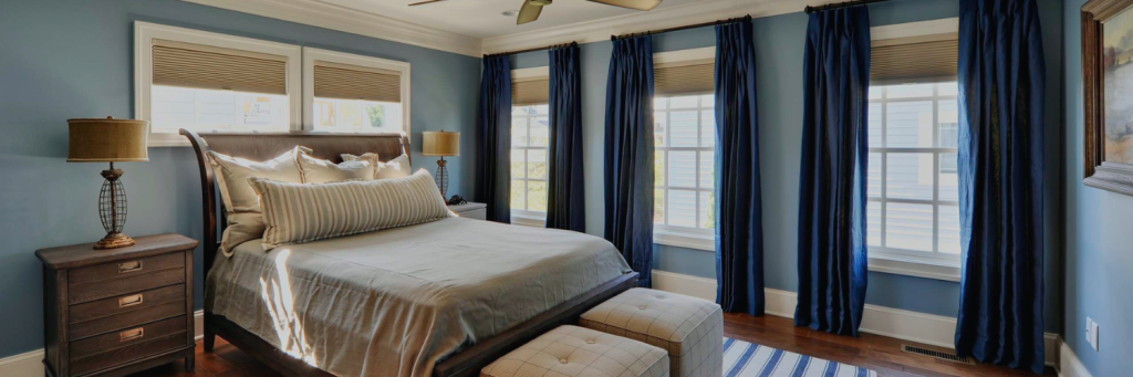 Dark blue floor-to-ceiling curtains in a cozy bedroom