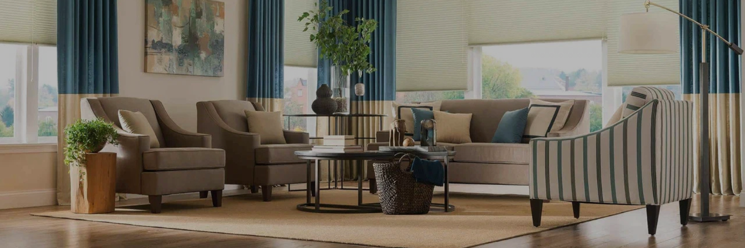 A modern living room featuring beige sofas, striped armchair, teal curtains, a round coffee table, and greenery, with bright natural light.