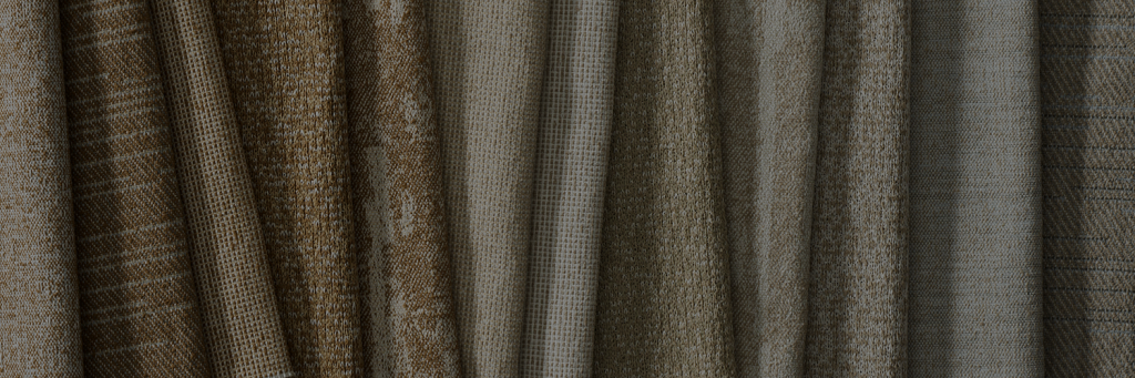 A collection of folded fabrics in various shades of brown and gray, showcasing different textures and patterns.