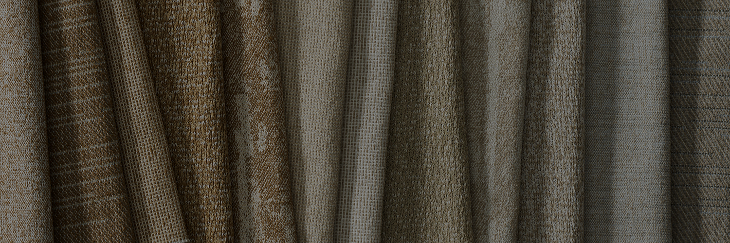 A collection of folded fabrics in various shades of brown and gray, showcasing different textures and patterns.