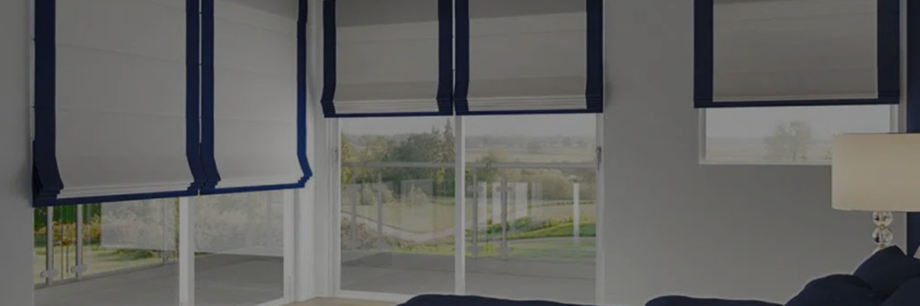 Bright living room with large windows featuring modern white roller shades accented with navy blue trim, revealing a scenic outdoor view.